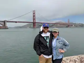 Laura and Bryce beside San Francisco Bay and the Golden Gate Bridge.