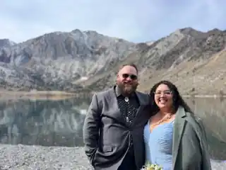 Laura and Bryce dressed up beside a mountain lake.