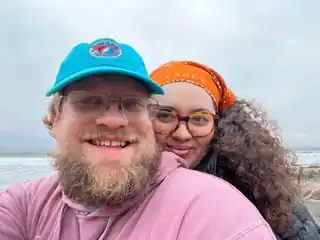 Laura and Bryce smiling together at the beach.