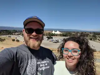 Laura and Bryce on a sunny overlook above a concert venue.
