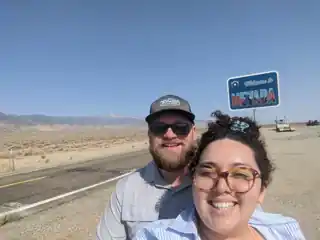 Laura and Bryce beside a Welcome to Nevada sign.
