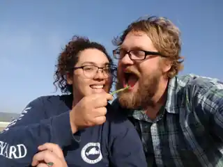 Laura and Bryce laughing together outside.